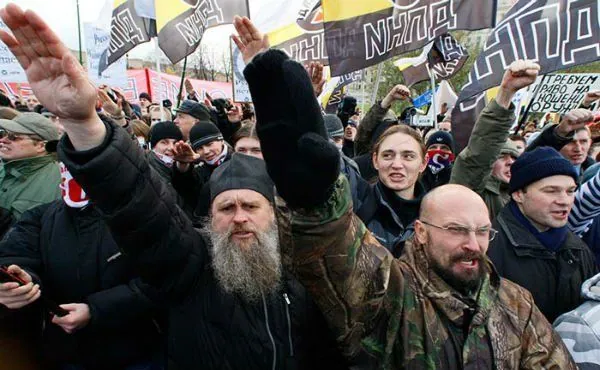 Мітинг радикалів: люди з чорно-жовто-білими імперськими прапорами піднімають руки в нацистському вітанні — етнічні та…