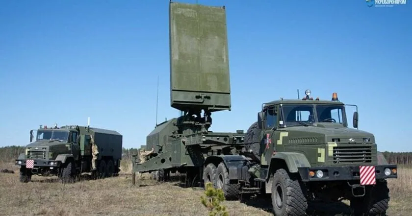 Мобільна станція радіоелектронної розвідки/РЕБ на шасі КрАЗ із великою підйомною плоскою фазованою антеною, поруч друга…