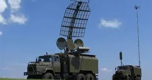 Станція РЕБ на шасі вантажівки з великою сітчастою антеною-рефлектором у полі, поруч допоміжний блок…
