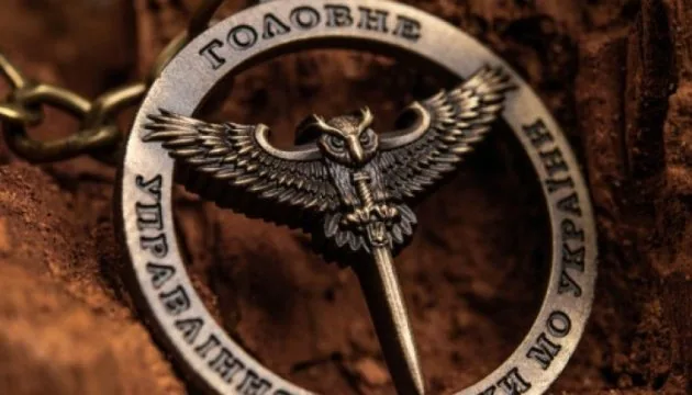 Металевий нагрудний знак Головного управління розвідки МО України: сова з розправленими крилами, що пронизує мечем, по…
