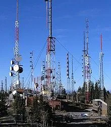 Кілька високих щоглових антенно-фідерних веж радіоцентру на тлі неба — радіозв'язок.