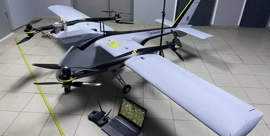 Гібридний БпЛА-конвертоплан CLEVERCOPTER/AIRMEDIC у приміщенні: літаковий планер із чотирма підйомними роторами на балках; поруч пульт, ноутбук із картою і рулетка для вимірів.