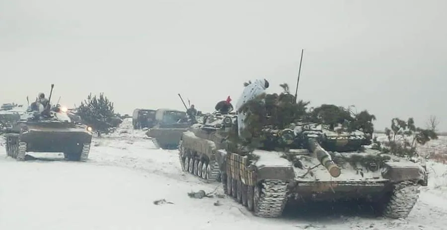 Колона бронетехніки (танки Т-64/Т-72 та БМП) із маскуванням гілками рухається засніженим полем — маневр підрозділу.